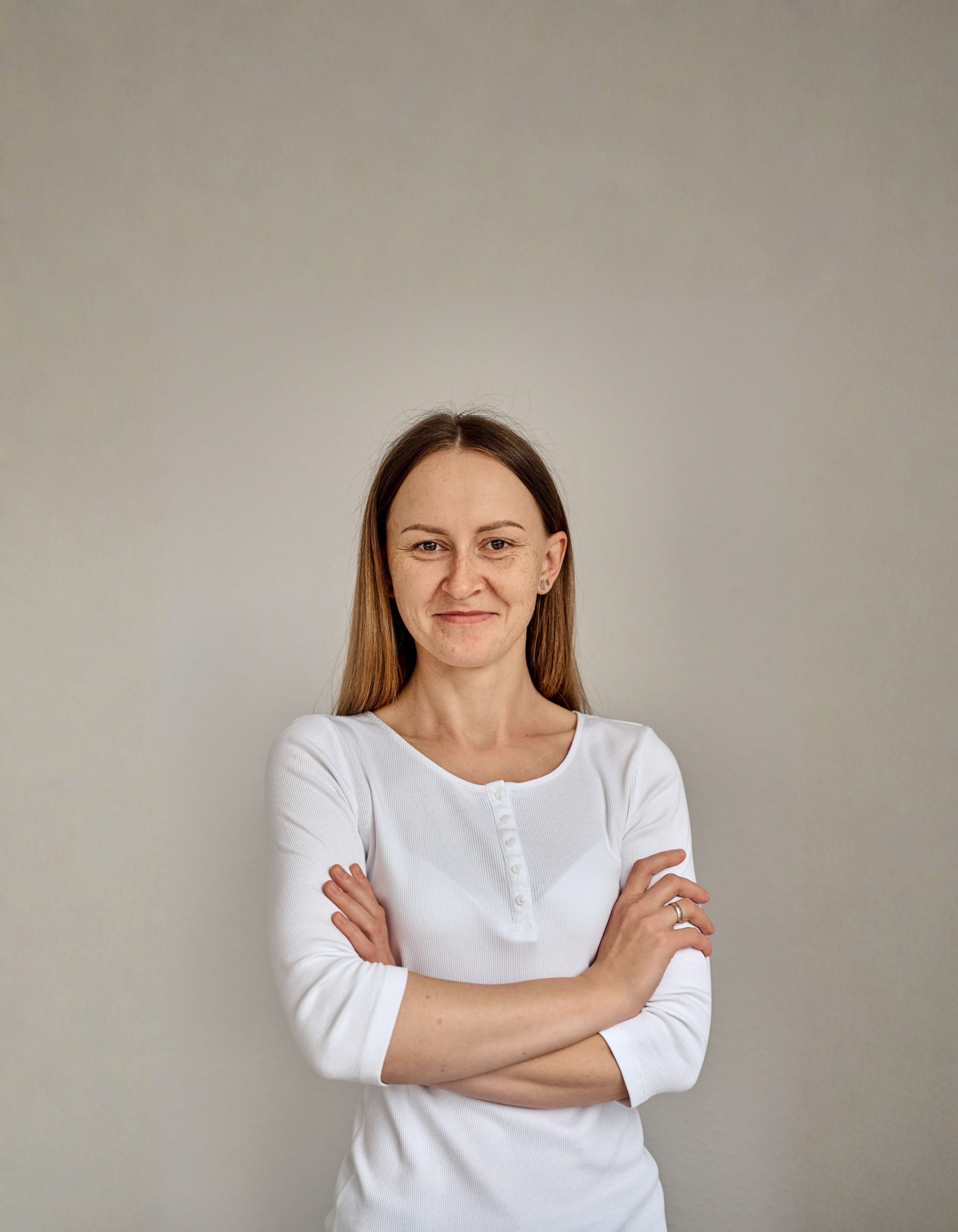 Porträt einer Physiotherapeutin in Ostfildern mit verschränkten Armen, die Kompetenz und Freundlichkeit ausstrahlt.